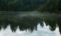 Hill mist on the kodaikanal lake at early morning with reflections. Royalty Free Stock Photo