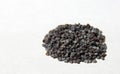 Hill of poppy seeds on white paper