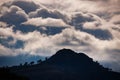 hill silhouetted under iridescent clouds Royalty Free Stock Photo