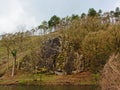 Hill slope with rocks and trees along Ourthe river, Liege, Belgium Royalty Free Stock Photo