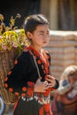 Hill tribe girl backpack with bamboo basket of flowers in parade