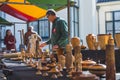 04.18.2023 Hillegom, Netherlands. Dutch male wood-working artist working at his market stall and selling his wooden