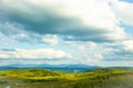 Hills with green grass and blue sky with white puffy clouds Royalty Free Stock Photo