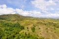 Hills with green grass and blue sky with white puffy clouds Royalty Free Stock Photo