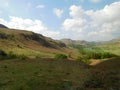 Hills in the Lake District in spring under blue sky with white clouds