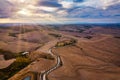 Hills, olive gardens and small vineyard under rays of morning sun, Italy, Tuscany. Famous Tuscany landscape with curved road and Royalty Free Stock Photo