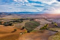 Hills, olive gardens and small vineyard under rays of morning sun, Italy, Tuscany. Famous Tuscany landscape with curved road and Royalty Free Stock Photo