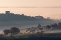 Hills and trees at dawn trough the mist and fog Royalty Free Stock Photo