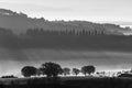 Hills and trees at dawn trough the mist and fog Royalty Free Stock Photo