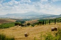 Hills of Tuscany with haycocks, fields and cypresses