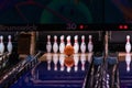 Orange bowling ball is about to hit center of pins at the end of a bowling alley Royalty Free Stock Photo