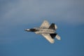 A US Air Force F-22 Raptor performs a demo at airshow . Grey plane against deep blue