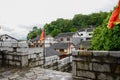 Hillside old-fashioned houses near stone wall in cloudy spring