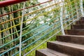 Hillside planked stairway with colorful steel handrail