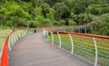 Hillside planked walkway with colorful steel railings in woods