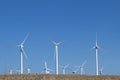 Hillside view wind farm bright white turbines blue sky Royalty Free Stock Photo