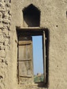 A Hilltop Fort spied through a shuttered window in Birkat Al Mauz