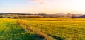 Hilly landscape illuminated by evening sunset. Green grass fields and hills on the horizont. Vivid spring rural Royalty Free Stock Photo