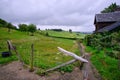 Hilly landscape, limburg the netherlands, green meadow with hay bales, in the foreground a wooden fence with signs with