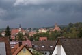 Hilpoltstein with Catholic parish church St. Johann Baptist and castle ruin under stormy sky