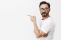 Is it him. Portrait of shocked and curious good-looking mature guy in glasses and t-shirt, standing in profile and Royalty Free Stock Photo