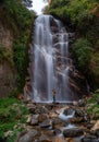 Himachal, India - April 7th, 2022 : Man overlooking waterfall in mountains of himalayas