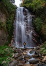 Himachal, India - April 7th, 2022 : Man overlooking waterfall in mountains of himalayas