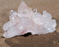 Himalayan clear quartz cluster with hematite inclusions on wet sand on the beach Royalty Free Stock Photo