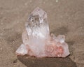 Himalayan clear quartz cluster with hematite inclusions on wet sand on the beach Royalty Free Stock Photo