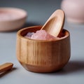 Himalayan pink salt in eco bowl with wooden spoon on the table. Blurred background with crockery