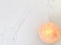 Himalayan pink salt lamp carved as a bowl with white marble background. copy space.