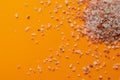 Himalayan pink salt pilel on orange background. Crystal salt