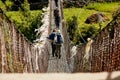 Trekkers and Sherpa crossing a suspension iron bridge in Everest base camp route. Royalty Free Stock Photo