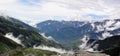 A Himalayan view, clouds touching the hills, greenery and vehicles on a circular road. Royalty Free Stock Photo