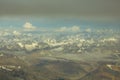 Himalayan yellow desert mountain valley with snowy peaks under a blue sky with white and gray clouds aerial view Royalty Free Stock Photo