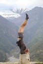 Portrait man standing on her head doing yoga in Himalayan mountain, Nepal Royalty Free Stock Photo