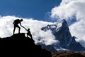 Teamwork couple hikers silhouette in mountains, climbers team