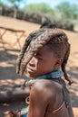 Himba girl with traditional hair locks posing for photographers