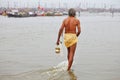 Hindu devotee is coming to confluence of Ganges and Yamuna River for ritual bathing