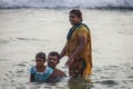 Hindu family do holy bathe at the sacred confluence on Papanasam beach