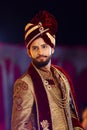 Hindu groom wedding day on stage wearing maroon dress and turban Royalty Free Stock Photo