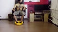 Hindu-looking guy with naked torso sits on chair, puts feet in yelllow washbawl