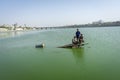 Hindu people crossing river on pieces of wood