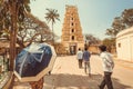 Hindu people walking to traditional Indian gopuram - tower of tample gate