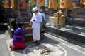 Hindu priest blessing Balinese family celebrating Galungan Kuningan holidays in Bali Indonesia