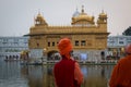 Hindu priest in orange turban stating at golden temple