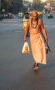 Hindu priest walking down busy street, India.