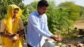 Hindu religious man with his wife offering food placed on a green leaf during a Hindu Ritual in the month of Sharada. Pitru paksha
