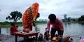 Hindu religious people worshipping lord Ganesha during immersion ceremony around river bank