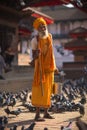 Hindu sadhu man and doves on Durbar square in Kathmandu